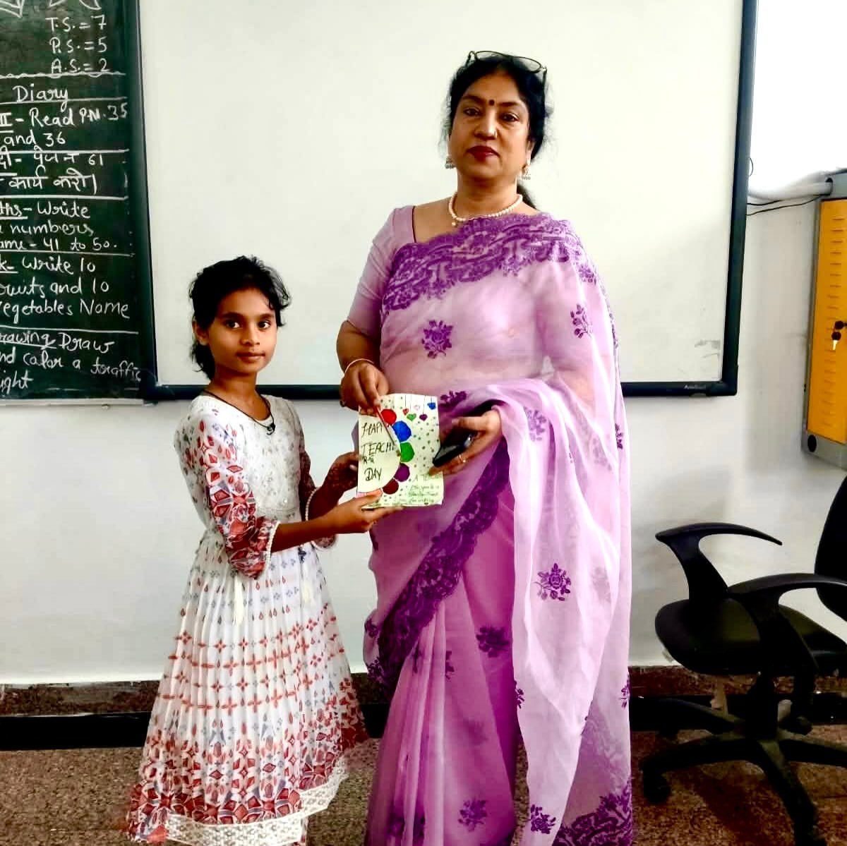 A student presents a handmade card to the Principal